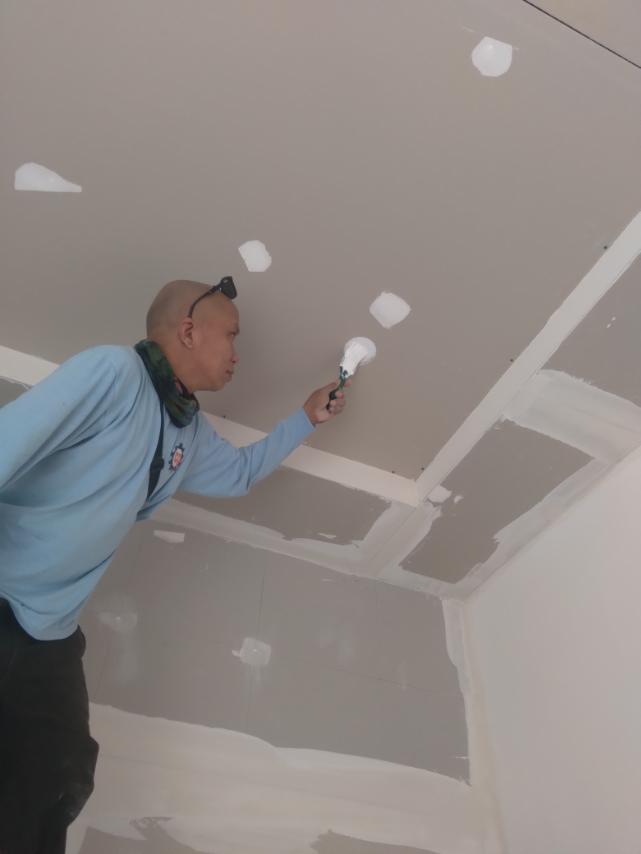 Site personnel finishing a ceiling installation