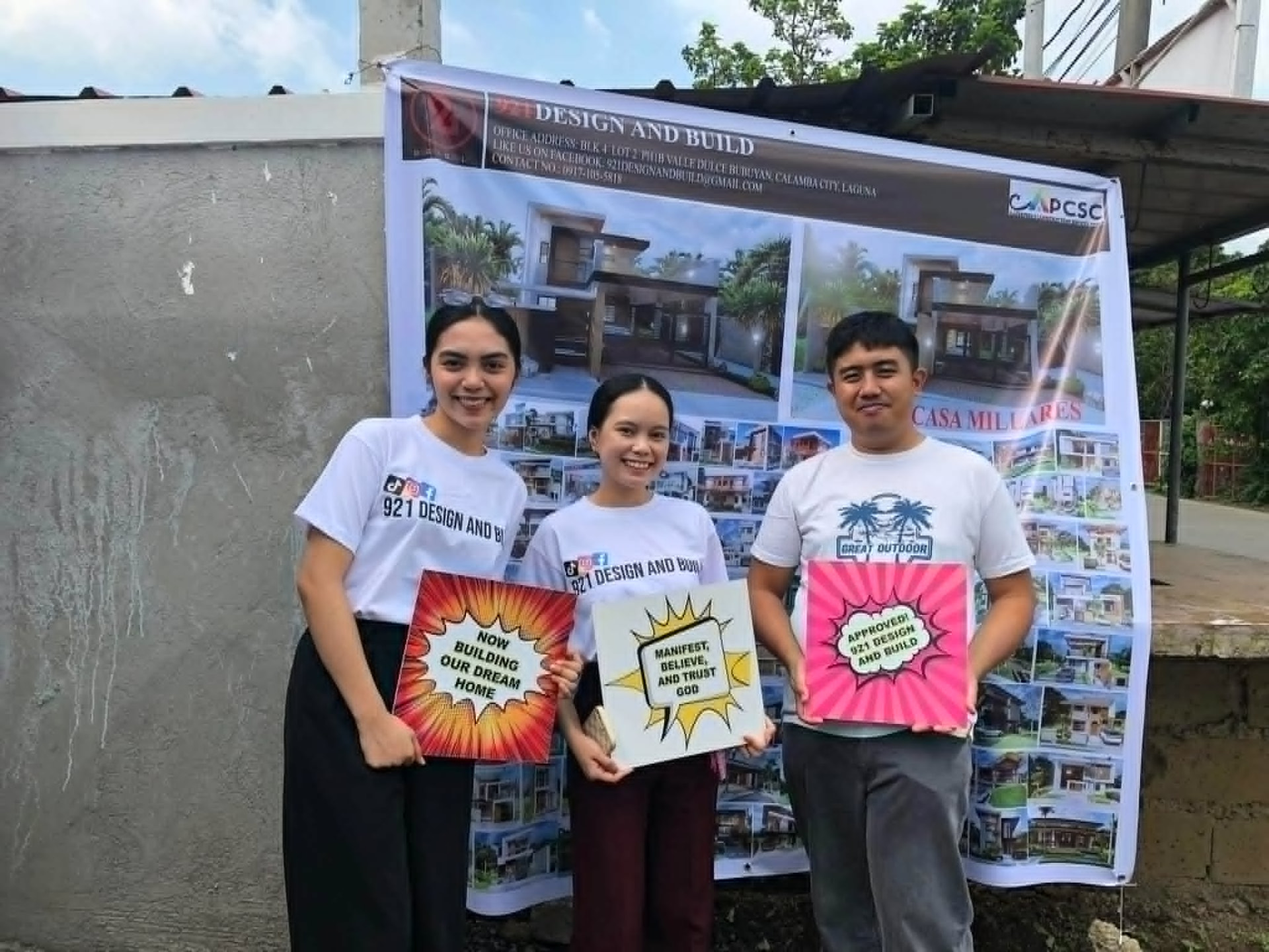 921 Design and Build team in front of a project tarpaulin